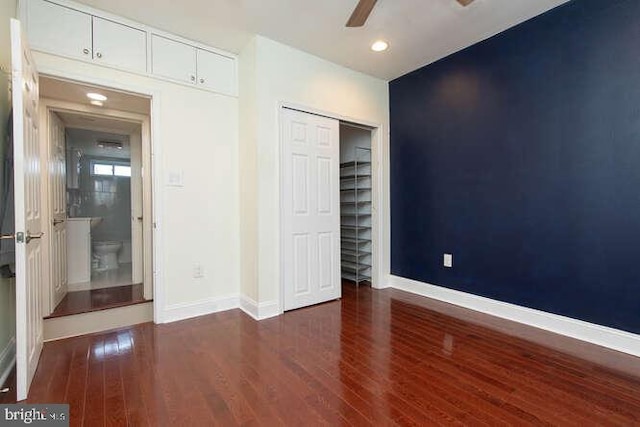 unfurnished bedroom with ceiling fan, dark wood-type flooring, and a closet