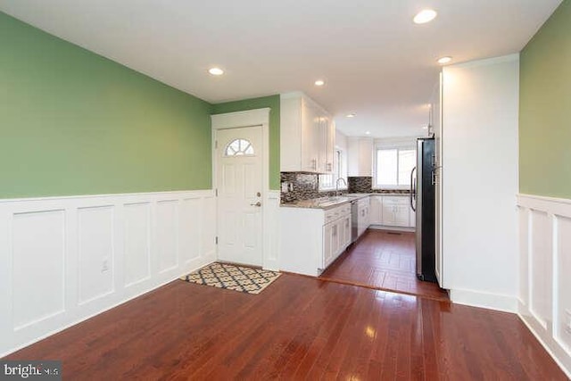 kitchen featuring backsplash, white cabinets, sink, dark hardwood / wood-style floors, and appliances with stainless steel finishes