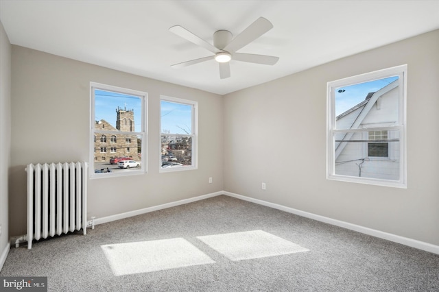 empty room featuring radiator, carpet floors, and ceiling fan