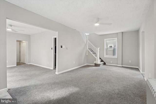 carpeted empty room with a textured ceiling, radiator heating unit, and ceiling fan