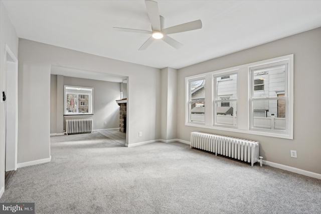 carpeted empty room with radiator heating unit and ceiling fan