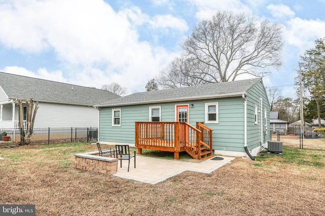 back of house with a lawn, a patio area, a wooden deck, and central AC