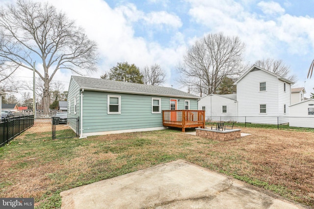 back of property with a lawn, a patio area, and a wooden deck