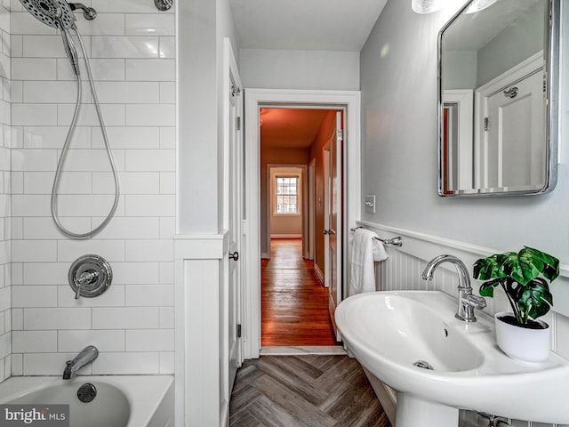 bathroom with parquet floors and tiled shower / bath