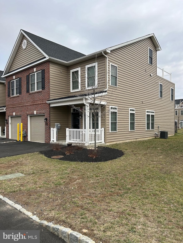 view of front of home with cooling unit, a front lawn, a porch, and a garage