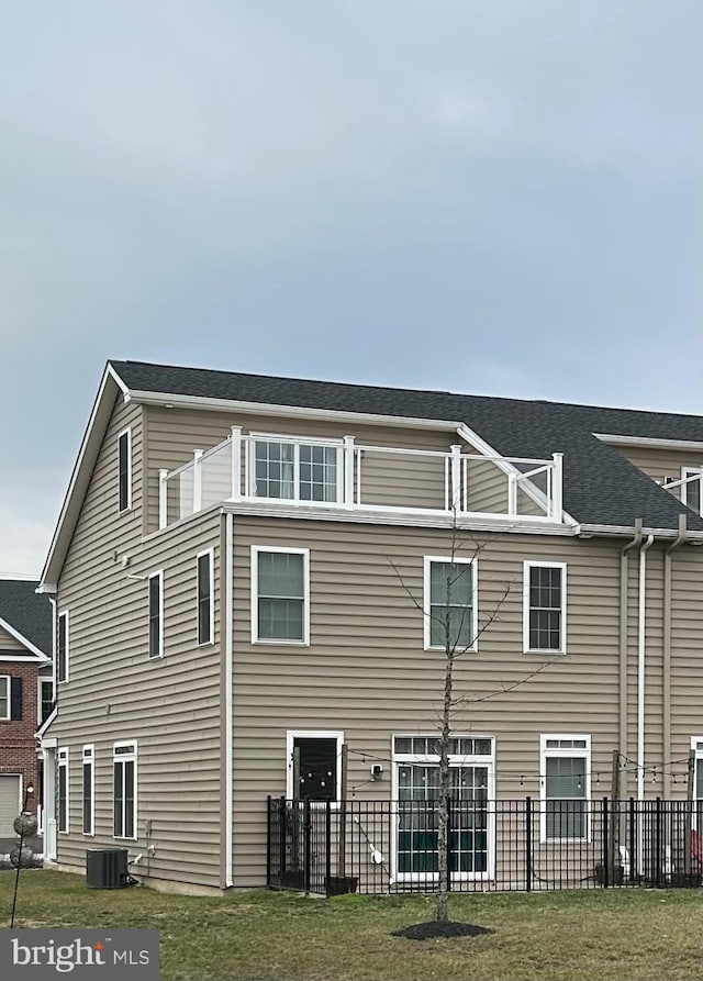 back of house with a yard and central AC unit