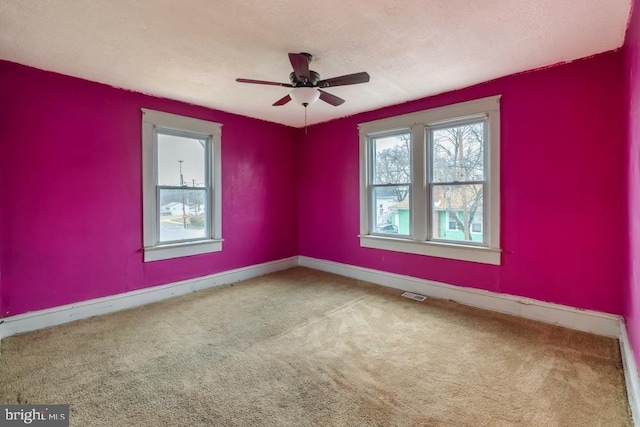 empty room featuring carpet and ceiling fan