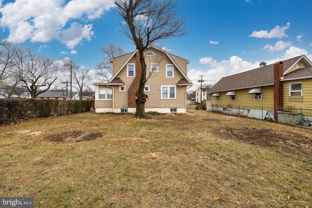 rear view of property with a lawn