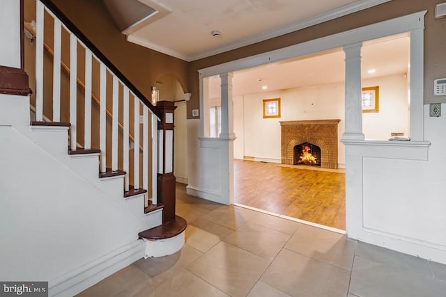 interior space with tile patterned floors, crown molding, and ornate columns