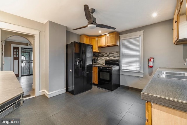 kitchen with black appliances, ceiling fan, backsplash, and sink