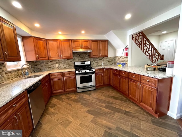 kitchen featuring light stone counters, sink, kitchen peninsula, and stainless steel appliances