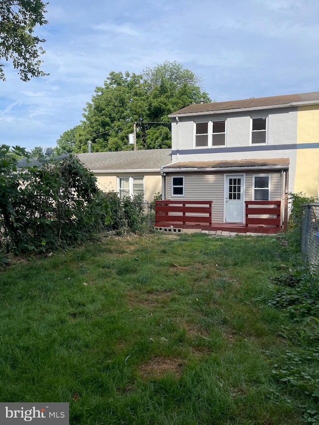 rear view of property featuring a lawn