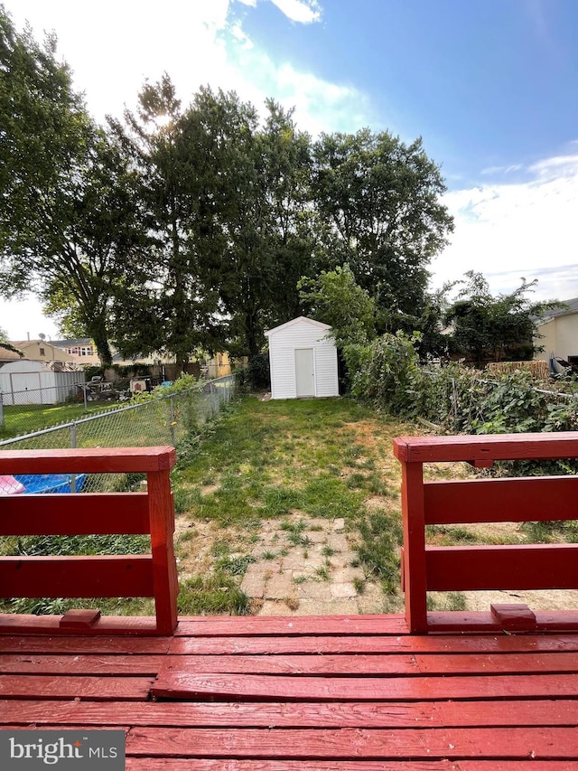 wooden terrace with a yard and a shed