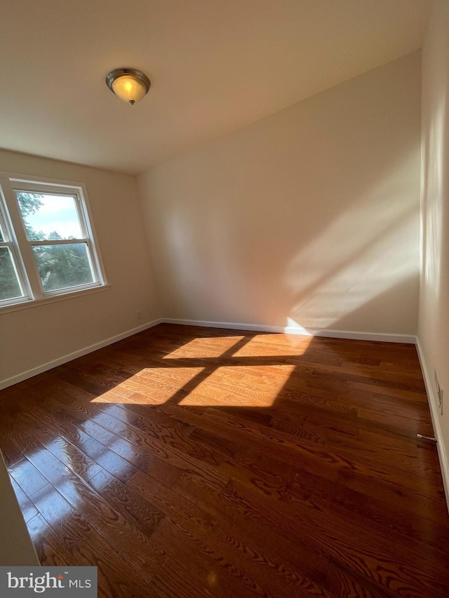 unfurnished room featuring dark wood-type flooring