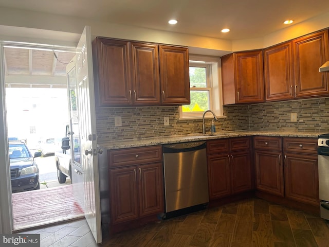 kitchen featuring tasteful backsplash, light stone counters, sink, and stainless steel dishwasher