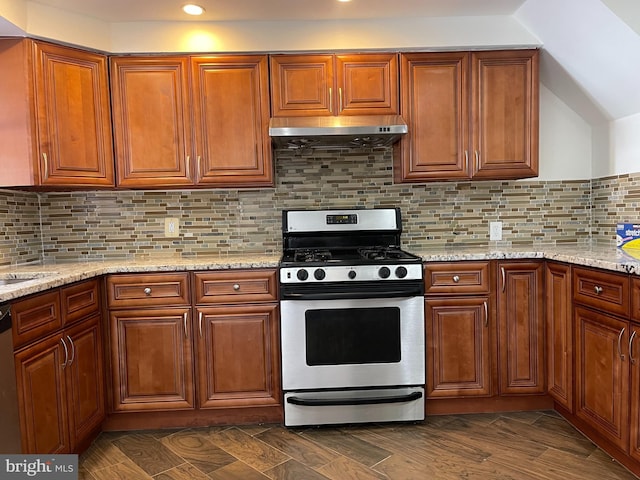 kitchen with light stone counters, gas range oven, and backsplash