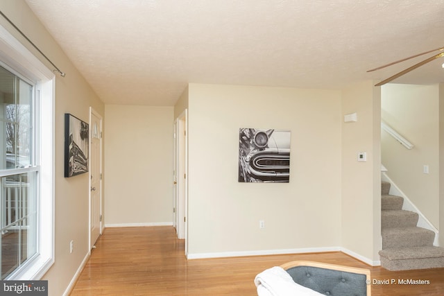 hall featuring a textured ceiling and light wood-type flooring