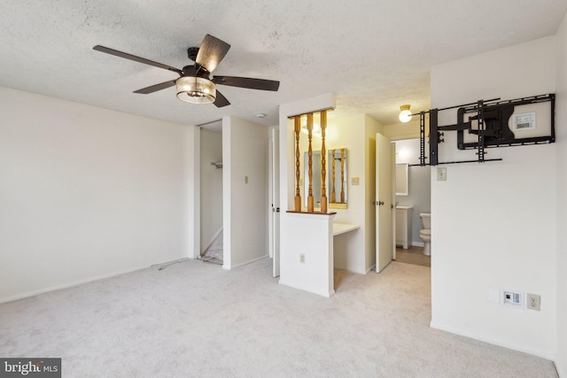 carpeted empty room with ceiling fan and a textured ceiling