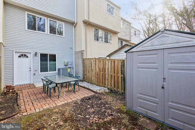 back of house featuring a patio and a storage unit