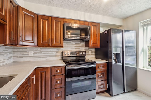 kitchen with a textured ceiling, decorative backsplash, light stone counters, and stainless steel appliances