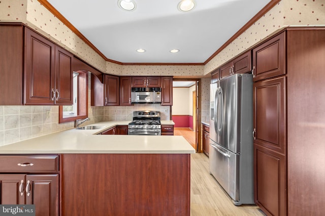 kitchen featuring ornamental molding, appliances with stainless steel finishes, kitchen peninsula, and sink