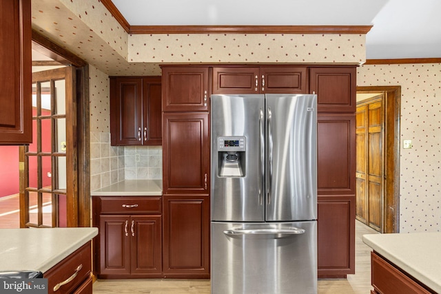 kitchen featuring crown molding, stainless steel fridge, and backsplash