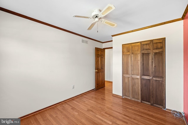 unfurnished bedroom featuring light hardwood / wood-style flooring, ornamental molding, a closet, and ceiling fan