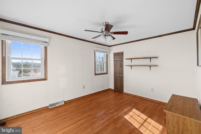 spare room featuring ceiling fan, wood-type flooring, and ornamental molding