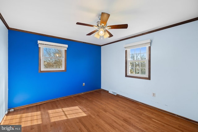 spare room with hardwood / wood-style floors, crown molding, and ceiling fan