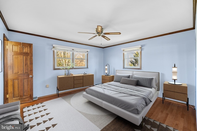 bedroom with hardwood / wood-style floors, ornamental molding, and ceiling fan