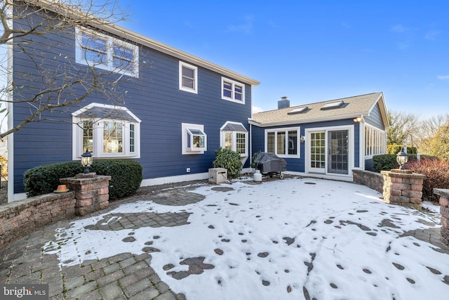 view of snow covered back of property