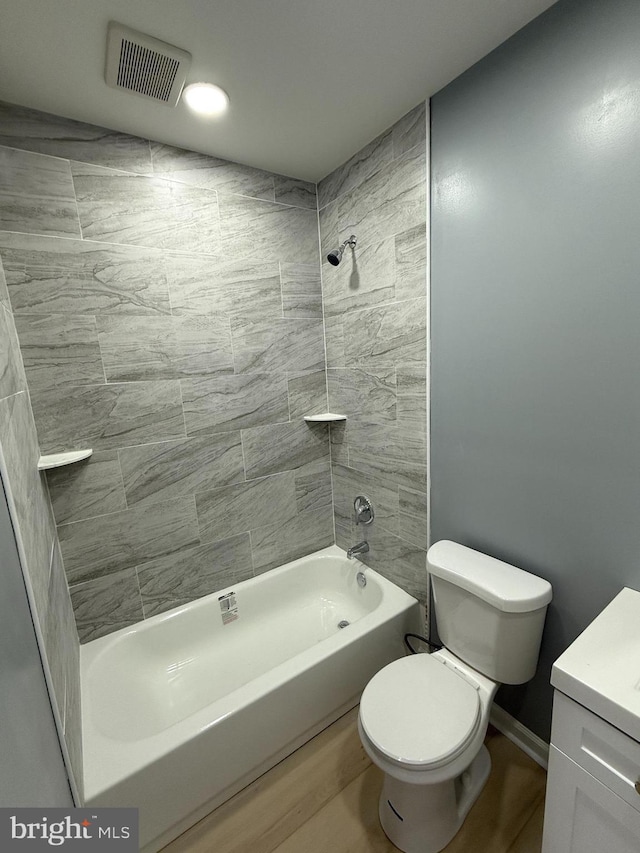 full bathroom featuring hardwood / wood-style flooring, toilet, vanity, and tiled shower / bath