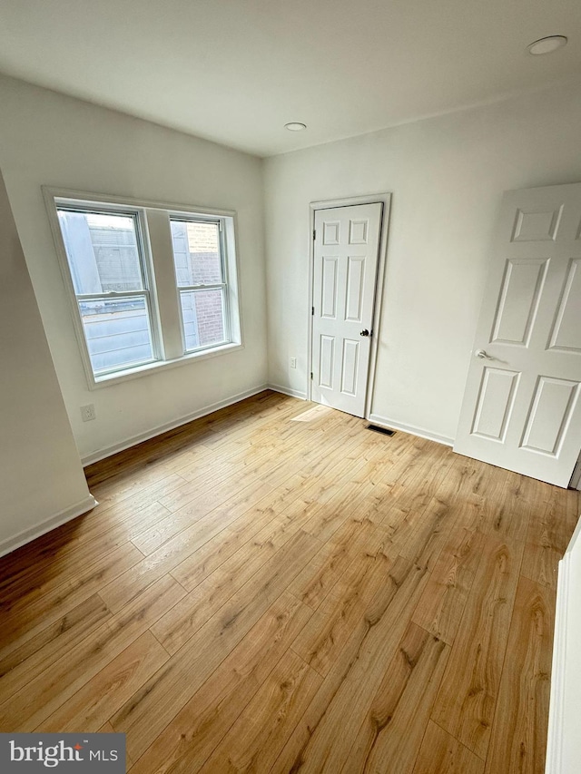 unfurnished room with light wood-type flooring