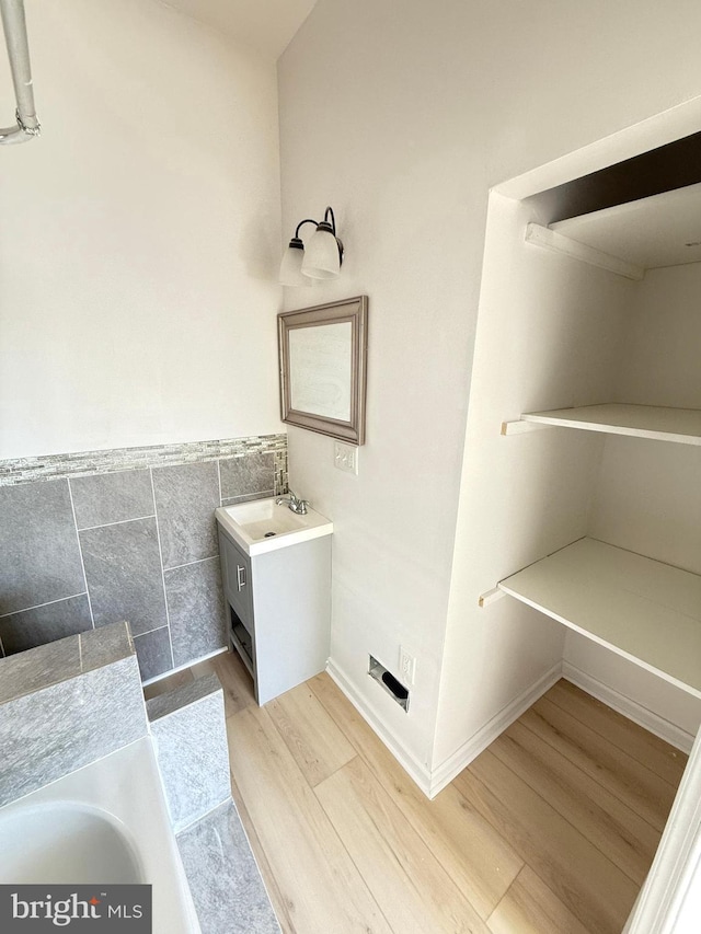 bathroom with vanity, hardwood / wood-style flooring, and tile walls