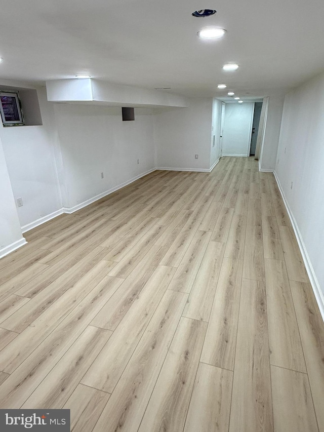 basement with light hardwood / wood-style floors