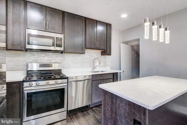 kitchen featuring sink, appliances with stainless steel finishes, dark hardwood / wood-style floors, pendant lighting, and backsplash