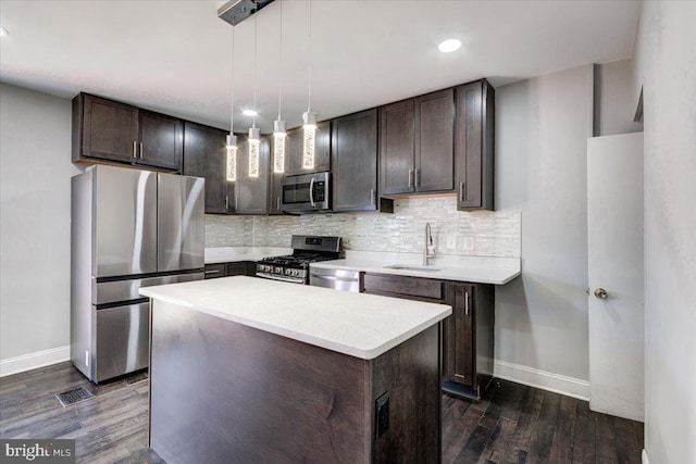 kitchen featuring sink, hanging light fixtures, a center island, dark brown cabinetry, and stainless steel appliances