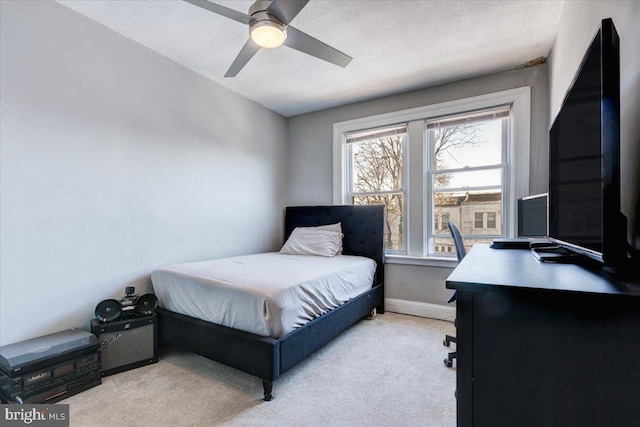 carpeted bedroom featuring a textured ceiling and ceiling fan