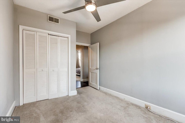 unfurnished bedroom with light colored carpet, ceiling fan, and a closet