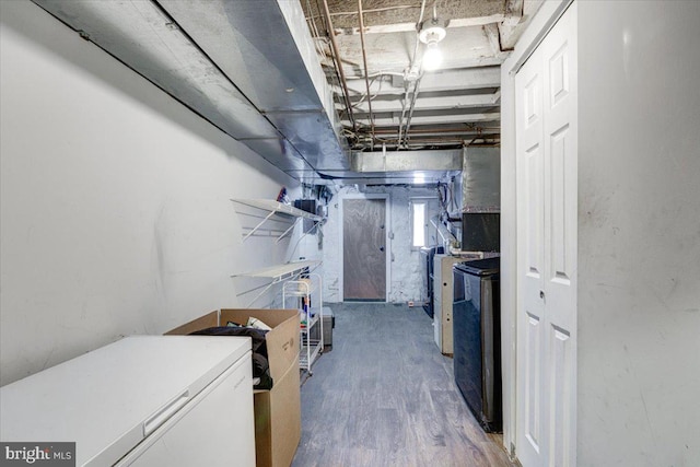 basement featuring fridge and hardwood / wood-style floors