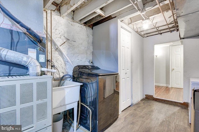 clothes washing area featuring hardwood / wood-style floors and sink