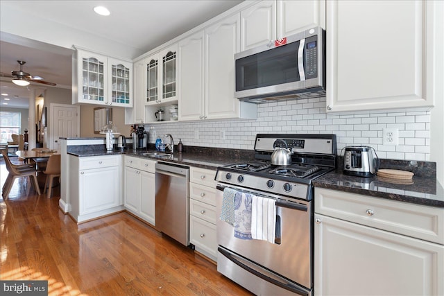 kitchen featuring white cabinetry, sink, hardwood / wood-style flooring, ceiling fan, and stainless steel appliances