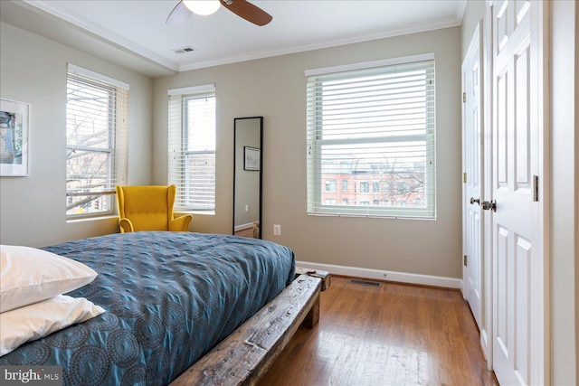 bedroom with crown molding, wood-type flooring, and ceiling fan