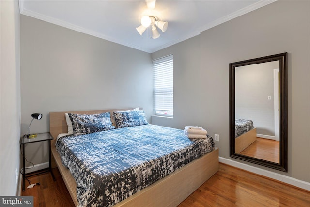 bedroom with wood-type flooring and crown molding