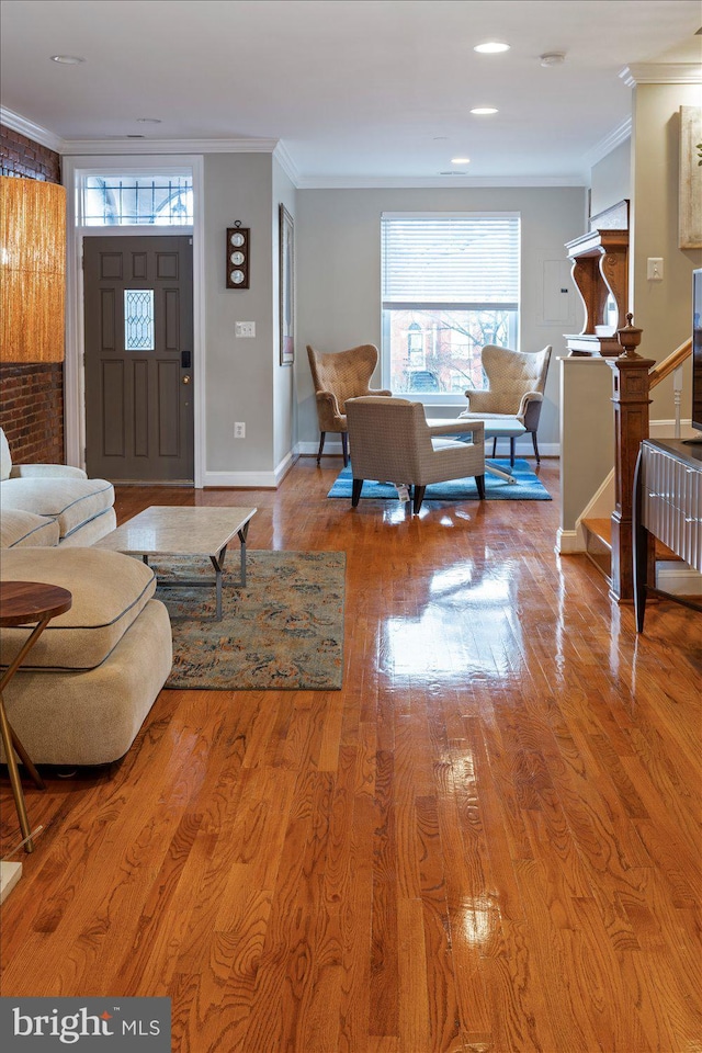 living room with crown molding, a healthy amount of sunlight, and hardwood / wood-style floors