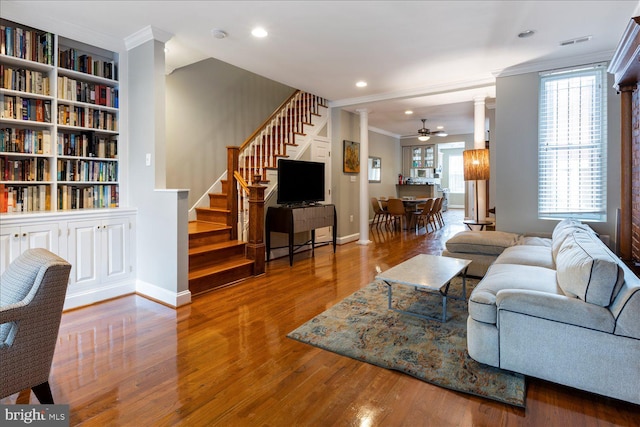 living room with decorative columns, crown molding, built in features, and ceiling fan