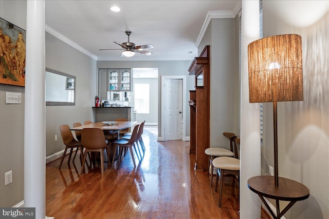 dining space with crown molding, ceiling fan, and hardwood / wood-style floors