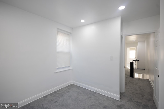 empty room featuring dark colored carpet