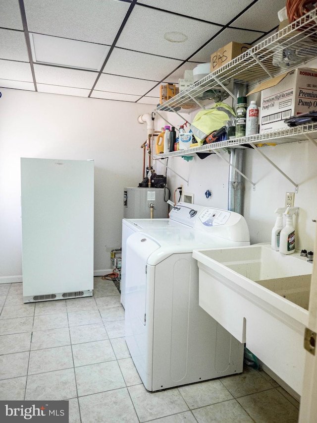 clothes washing area featuring a sink, laundry area, washing machine and clothes dryer, and tile patterned floors