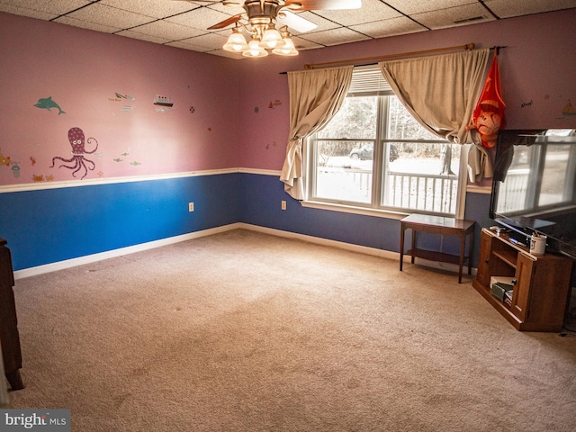 interior space featuring carpet floors, a ceiling fan, baseboards, and a paneled ceiling